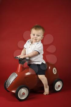 Royalty Free Photo of a Toddler Boy Riding a Toy Car
