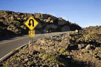 Royalty Free Photo of a Road and Curve in a Road Sign in Haleakala National Park, Maui, Hawaii.