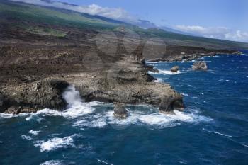 Aerial of Pacific ocean and Maui, Hawaii coast with waves hitting lava rocks.