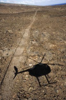 Royalty Free Photo of a Pathway Leading Through Rocky Terrain With a Shadow of a Helicopter Flying Overhead in Maui, Hawaii