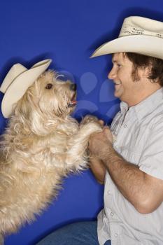 Royalty Free Photo of a Man and a Dog Wearing Cowboy Hats