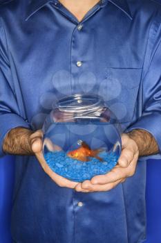 Royalty Free Photo of a Man Holding a Goldfish in a Bowl