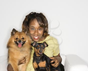 Royalty Free Photo of a Woman Holding a Pomeranian and Miniature Pinscher Dogs