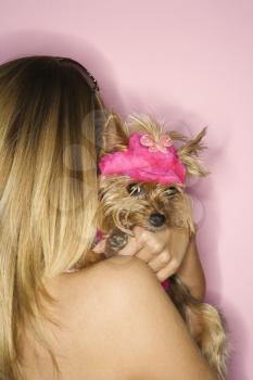 Caucasian young adult female holding Yorkshire Terrier dog.