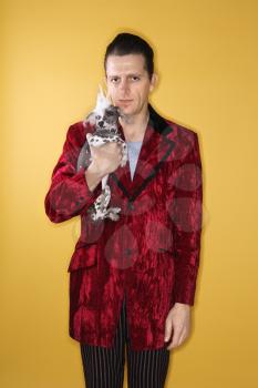 Royalty Free Photo of a Male Wearing Velvet and Holding a Chinese Crested Dog