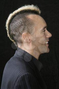 Royalty Free Photo of a Man in Suit with a Mohawk Against a Black Background