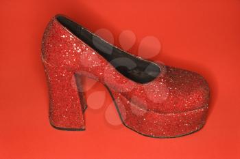 Royalty Free Photo of a Red Glitter High Heel Shoe Against a Red Background