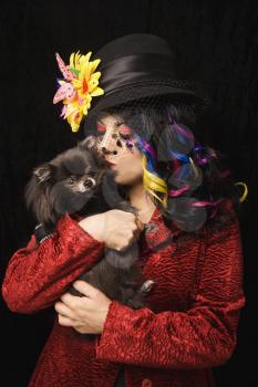 Royalty Free Photo of a Woman Wearing Unique Makeup Holding a Pomeranian 