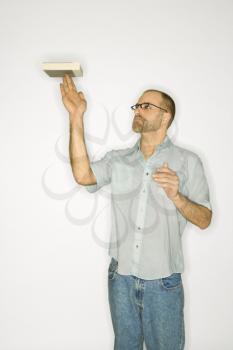 Royalty Free Photo of a Man Balancing a Book on His Fingers