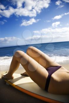 Royalty Free Photo of a Young Woman in a Bikini Lying on a Surfboard Sunbathing at a Beach in Maui Hawaii