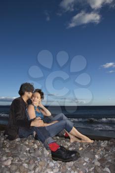 Royalty Free Photo of a Couple Sitting Close on a Beach