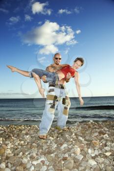 Royalty Free Photo of a Man Carrying a Woman on the Beach