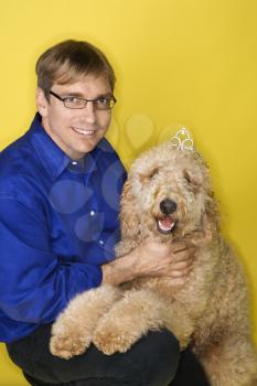 Middle-aged Caucasian man with Goldendoodle dog.