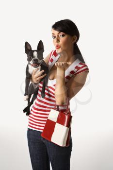 Royalty Free Photo of a Woman Holding a Boston Terrier and Blowing a Kiss