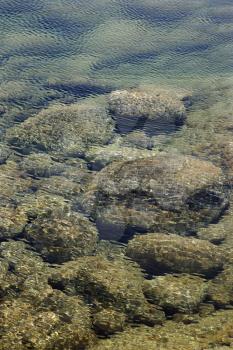 Royalty Free Photo of Rocks on the Ocean Bottom Seen Through Clear, Rippled Water in Maui, Hawaii, USA