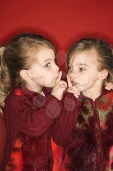 Royalty Free Photo of Twins Holding Fingers to Their Lips