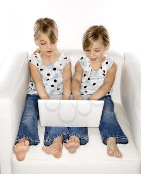 Royalty Free Photo of Twins Playing With a Laptop Computer