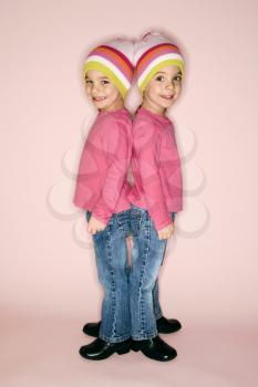 Royalty Free Photo of Twin Girls Standing Back to Back