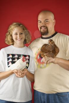 Royalty Free Photo of a Man and Woman Holding Chickens
