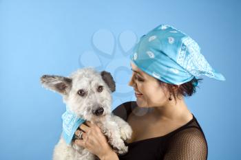 Royalty Free Photo of a Woman Holding a Small White Dog Wearing Matching Bandannas