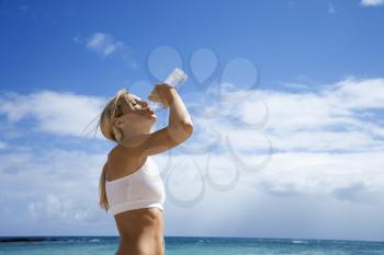 Royalty Free Photo of a Woman Drinking Water on a Beach