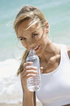 Royalty Free Photo of a Woman Drinking Water on a Beach
