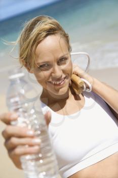 Royalty Free Photo of a Woman Holding a Jump Rope and Water Bottle on a Beach