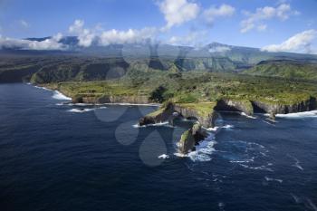 Royalty Free Photo of an Aerial of a Rocky Coast on Pacific Ocean With Mountains in the Background in Maui, Hawaii