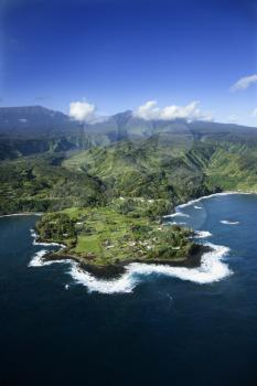 Royalty Free Photo of an Aerial of a Rocky Coast on Pacific Ocean With Mountains in the Background in Maui, Hawaii