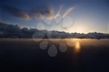 Royalty Free Photo of an Aerial of the Sun Setting Over the Pacific Ocean With Clouds