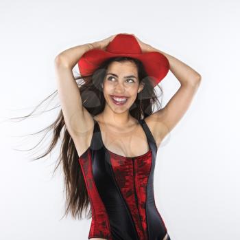 Royalty Free Photo of a Woman in a Corset With Her Hand on Top of a Red Cowboy Hat