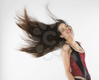 Caucasian woman wearing corset swinging her hair.