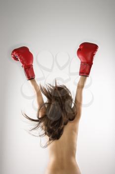 Royalty Free Photo of a Topless Woman Wearing Boxing Gloves With Arms in the Air