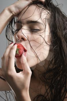 Royalty Free Photo of a Topless Woman Biting a Strawberry