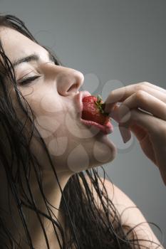 Royalty Free Photo of a Woman Biting a Strawberry