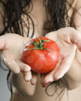 Royalty Free Photo of a Topless Woman Holding Tomatoes