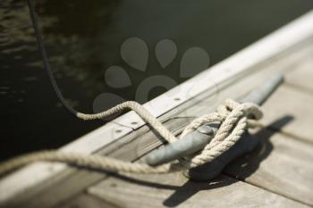 Royalty Free Photo of Rope Tied to a Cleat on a Boat Dock