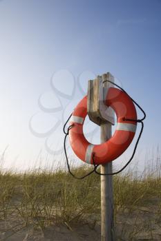 Life preserver hanging on post on beach on Bald Head Island, North Carolina.