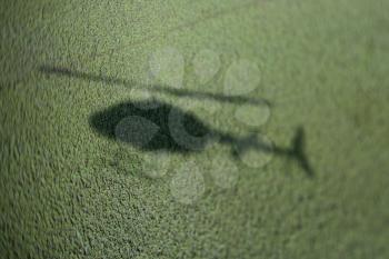 Royalty Free Photo of a Shadow of a Helicopter Above a Green Marsh With Abundant foliage