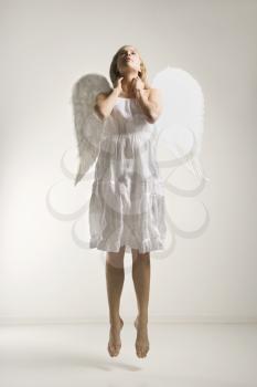 Royalty Free Photo of a Woman in a White Angel Costume Jumping in the Air