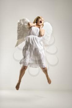 Royalty Free Photo of a Woman in an Angel Costume Jumping