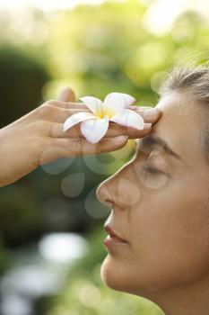 Royalty Free Photo of a Woman Holding a Plumeria Flower