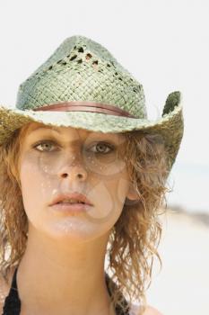 Royalty Free Photo of a Woman on a Beach Wearing a Cowboy Hat