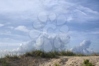 Royalty Free Photo of a Sand Dune With Beach Grass and Cloudy Sky
