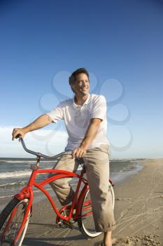 Royalty Free Photo of Man Riding a Bicycle on the Beach
