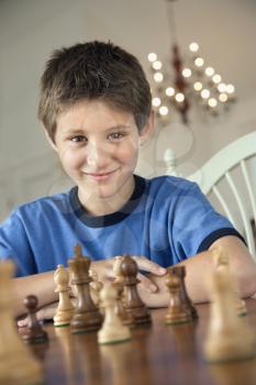 Caucasian pre-teen boy playing chess.