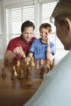 Royalty Free Photo of a Father Teaching Chess to His Son
