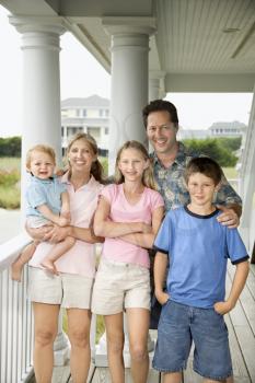 Royalty Free Photo of a Family Standing on the Porch 