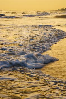 Royalty Free Photo of Waves Lapping on a Beach at Sunset