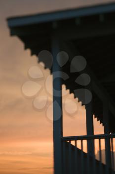 Royalty Free Photo of a Beachfront Porch Silhouetted at Sunset